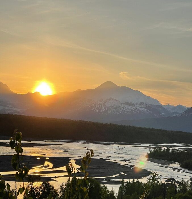 The midnight sun setting behind Mt. Denali